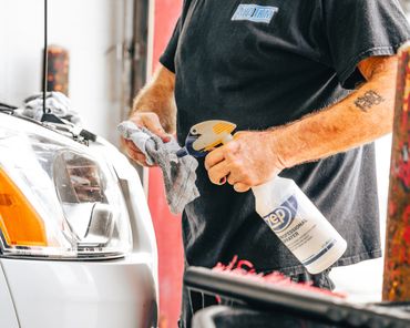 Man preparing microfiber wash cloth with detailing cleaning solution.