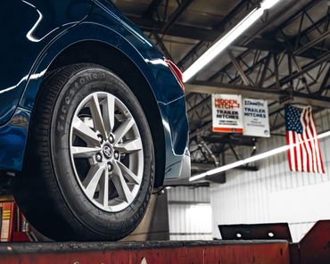 Fleet vehicle on commercial grade hoist prepped for rustproofing in Madison, Wisconsin.