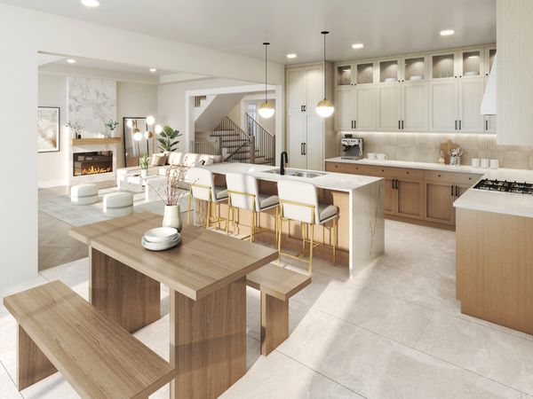 Bright open kitchen and living area with wooden dining table and modern island seating.