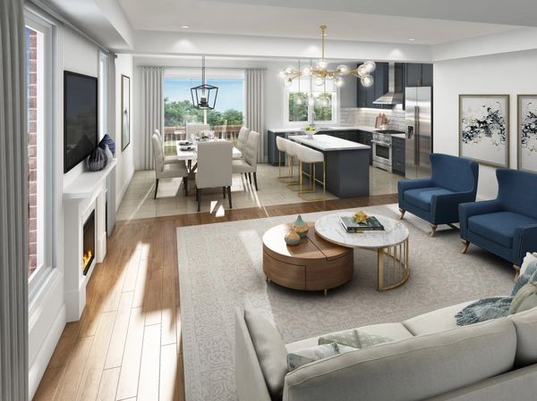 Modern open-concept living room with kitchen and dining area, featuring blue chairs and a cozy fireplace.