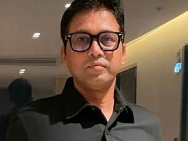 Man wearing glasses and a black shirt indoors.