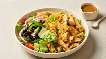 Grilled chicken salad with fresh vegetables and dressing.