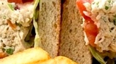 Bacon club sandwiches with pickle and fries.
