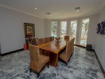 Dining room with wicker chairs and ocean view windows.