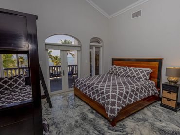Cozy bedroom with patterned bedding and ocean view balcony.