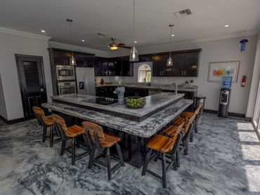 Modern kitchen with marble countertops and wooden bar stools.