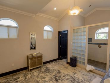 Modern bathroom with frosted glass shower walls and marble flooring.