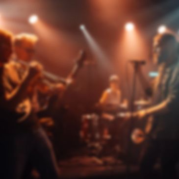 A band performing live on stage with warm lighting.