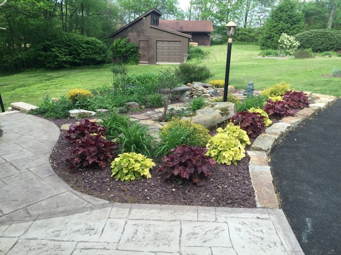 A blend of Coral Bells along with a custom walkway enhance this beautiful home.