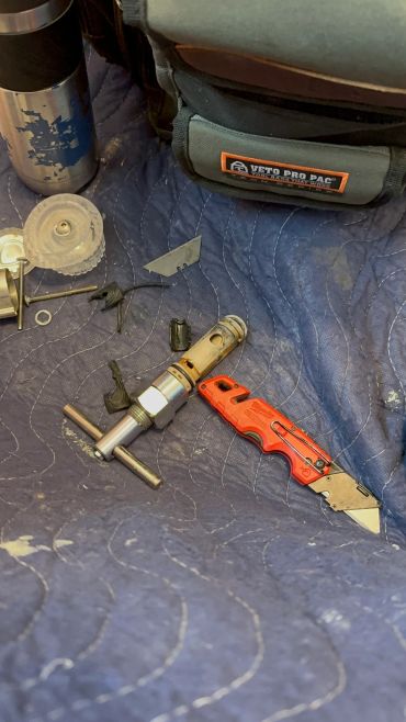 Tools and broken parts on a blue quilted surface.