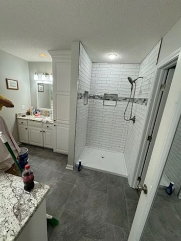 Modern bathroom with a walk-in shower and white cabinetry.
