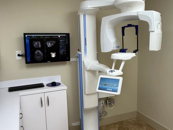 Dental imaging machine with monitor displaying dental scans.