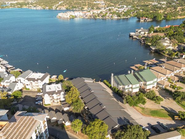 Aerial view of lakeside residential area with houses and calm water.