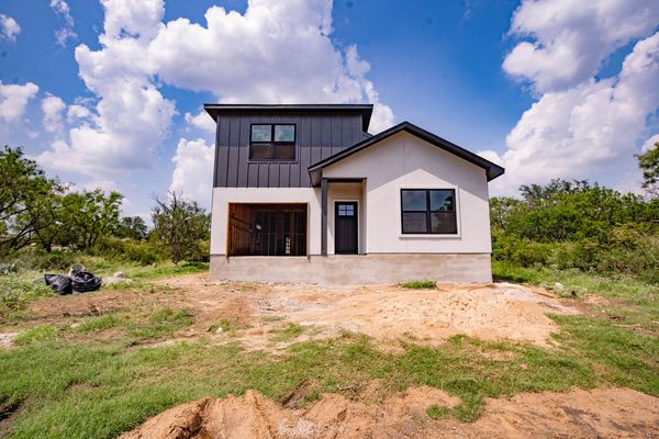 Newly constructed modern house with black and white exterior under a blue sky.
