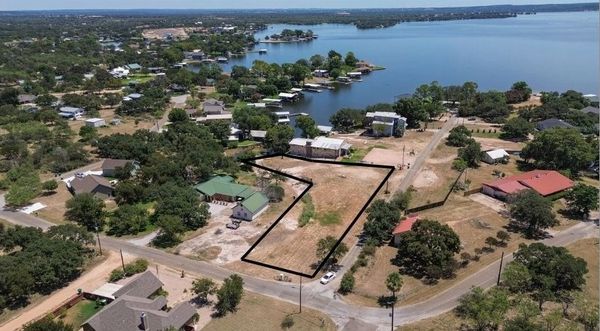 A lakeside residential area with marked vacant land for sale.