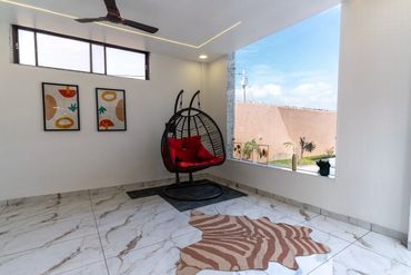 Modern indoor space with a hanging chair and large window.
