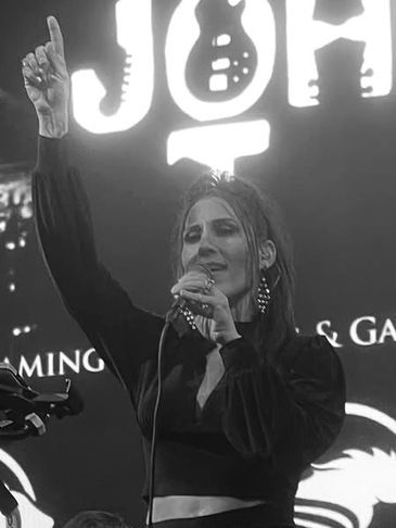 Female singer passionately performing on stage with microphone.