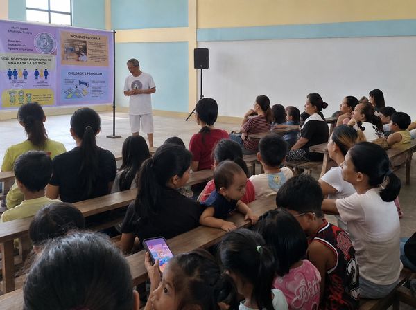 Community gathering in a classroom for a program.