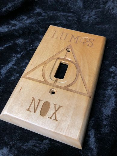 Handmade laser engraved light switch cover with the text "nox" and "lumos" designed by Pirate Monkeyt