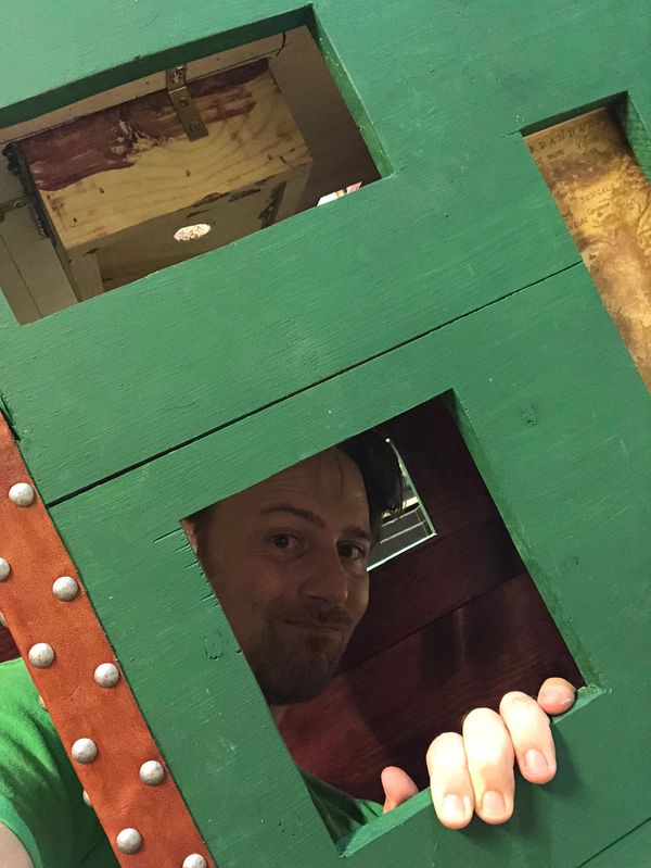 Owner of Pirate Monkey Art peering out of wooden box.