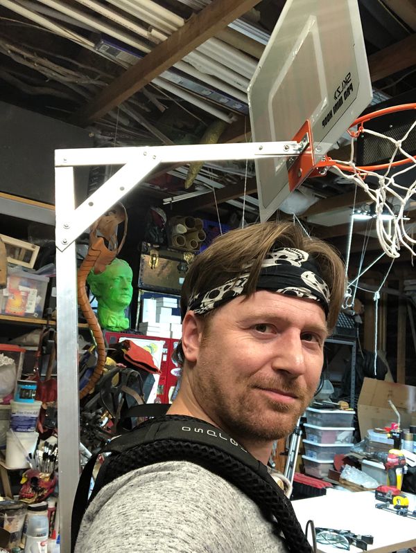 Owner of Pirate Monkey Art wearing basketball hoop prop.