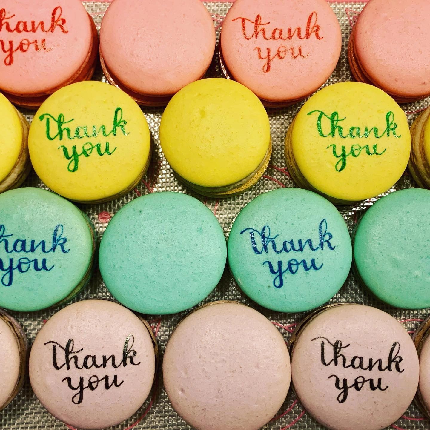 pastel macarons with Thank You written on them in edible marker
