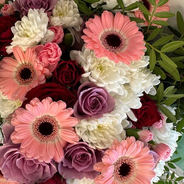A bouquet of mixed flowers with pink, red, white, and purple blossoms.