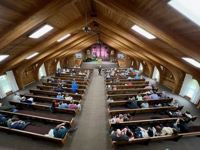 People gathered in a wooden church interior.