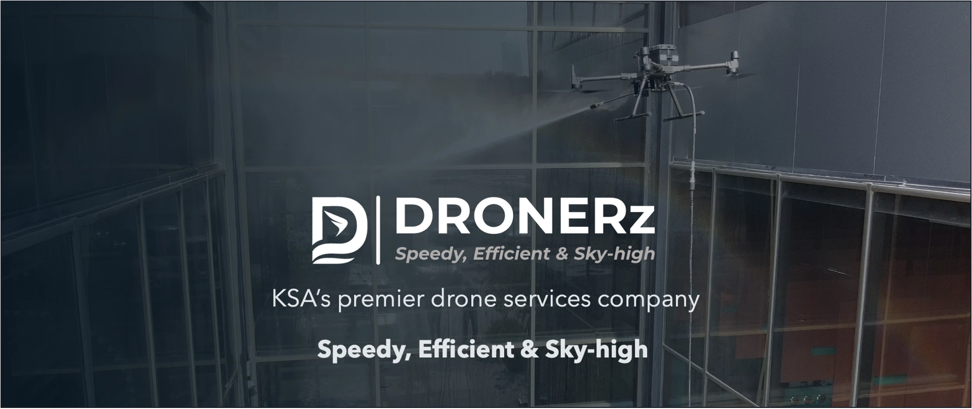 Drone spraying water on building windows for cleaning services.