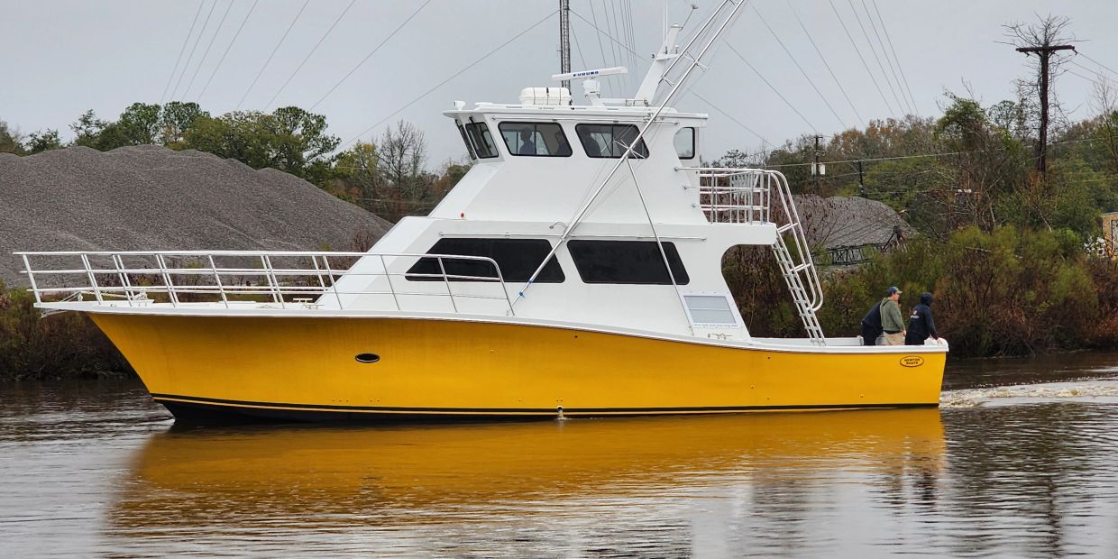 Yellow and white fishing boat on a calm river.