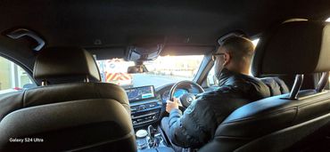 Man driving a modern BMW with a navigation system visible.