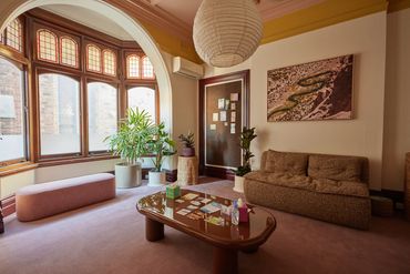 Cozy room with a sofa, plants, and a decorative window.