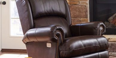 brown leather recliner with power options on side of chair
