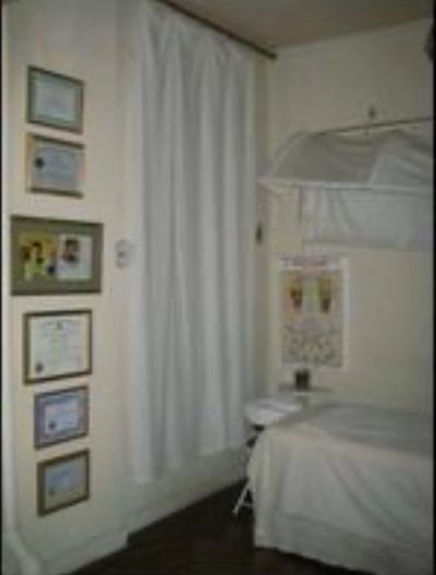 A cozy therapy or massage room with certificates on the wall.