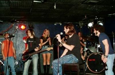 Band performing live on stage in a small venue.