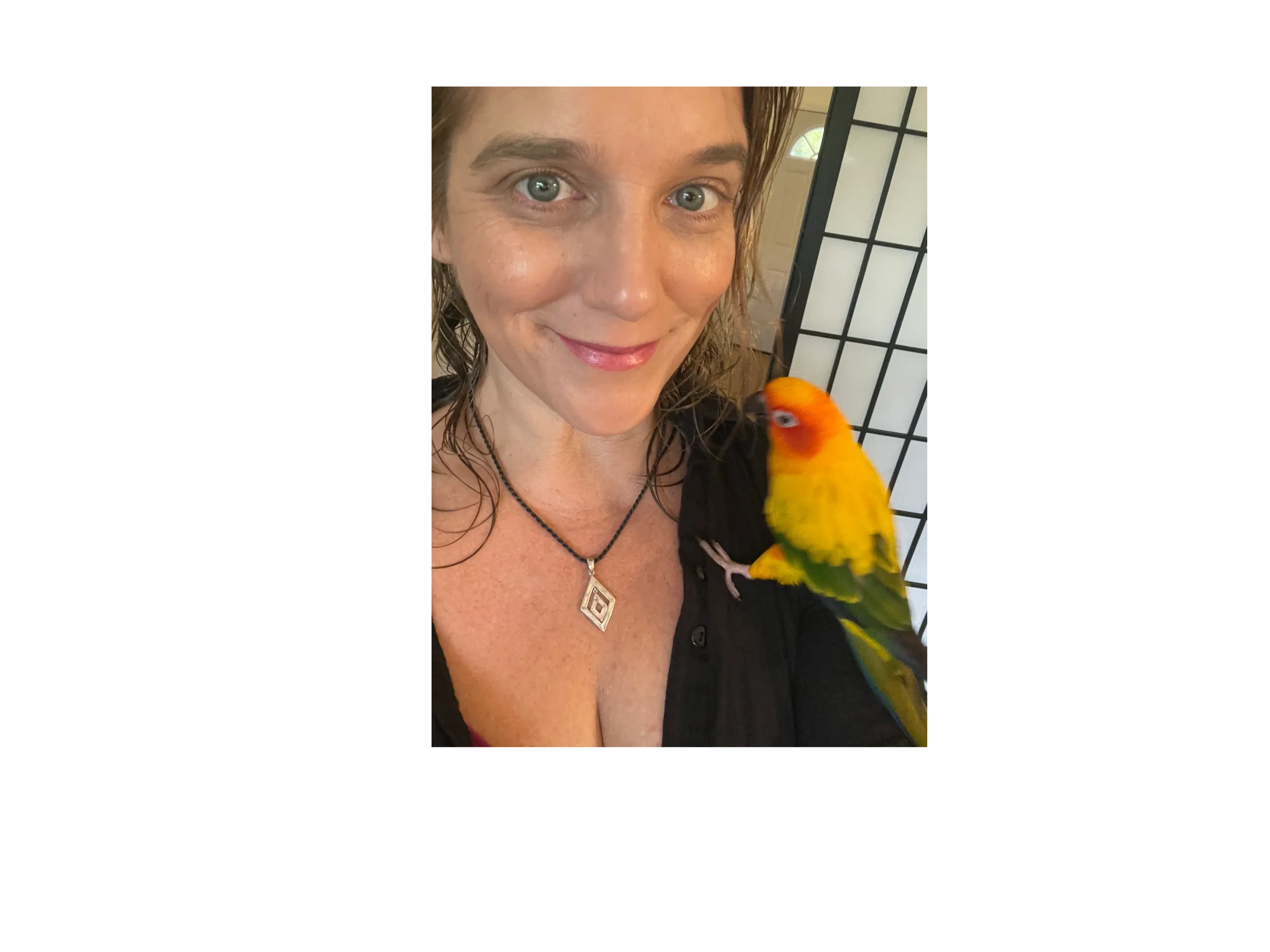 Photograph of abstract artist Lockey White with a conure on her shoulder.