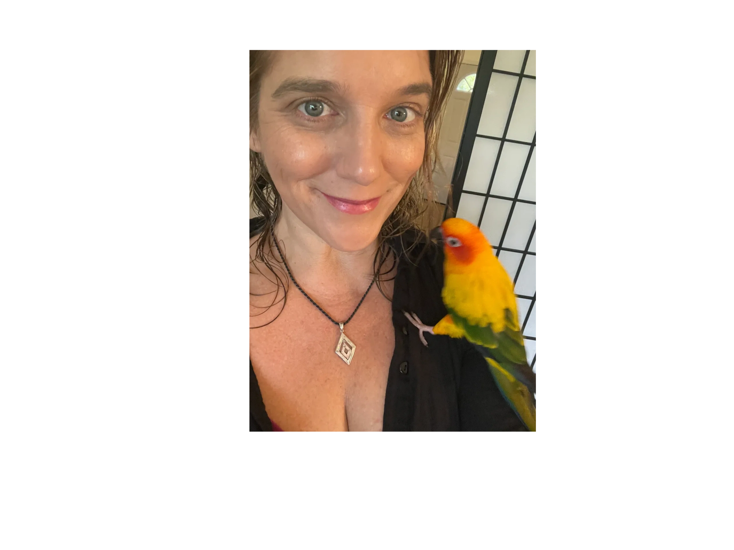 Photograph of abstract artist Lockey White with a conure on her shoulder. 