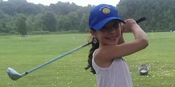 Junior girl golfer posing for a picture.