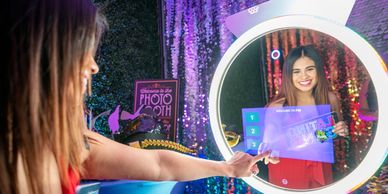 Capture the moment as a woman enjoys pressing the start button on our mirror photo booth.