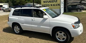 White SUV parked outside Sunshine Auto Sales.