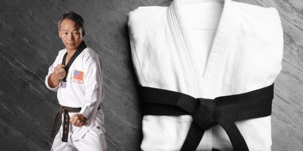 Martial artist and folded white gi with black belt.