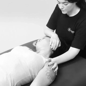 Massage Therapist stretching client's neck who is experiencing neck pain after working out