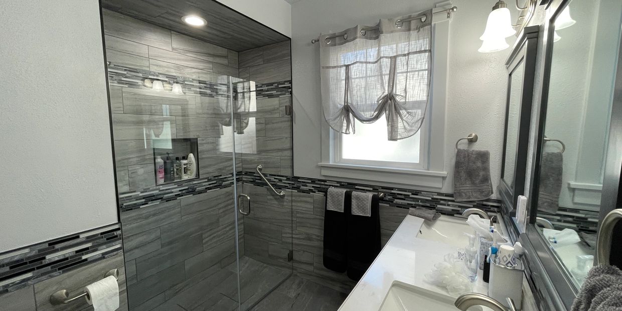 Completed La Grande bathroom remodel with a custom gray tile shower, glass enclosure, vanity, and co