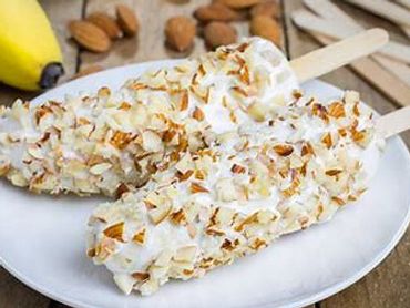 Two almond-covered ice cream bars on a white plate.