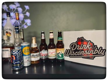 Various alcoholic beverages displayed beside a sign saying 'Drink Wisconsinbly'.