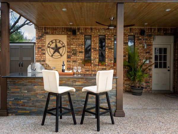 an outdoor bar with brick facade and seating for two people
