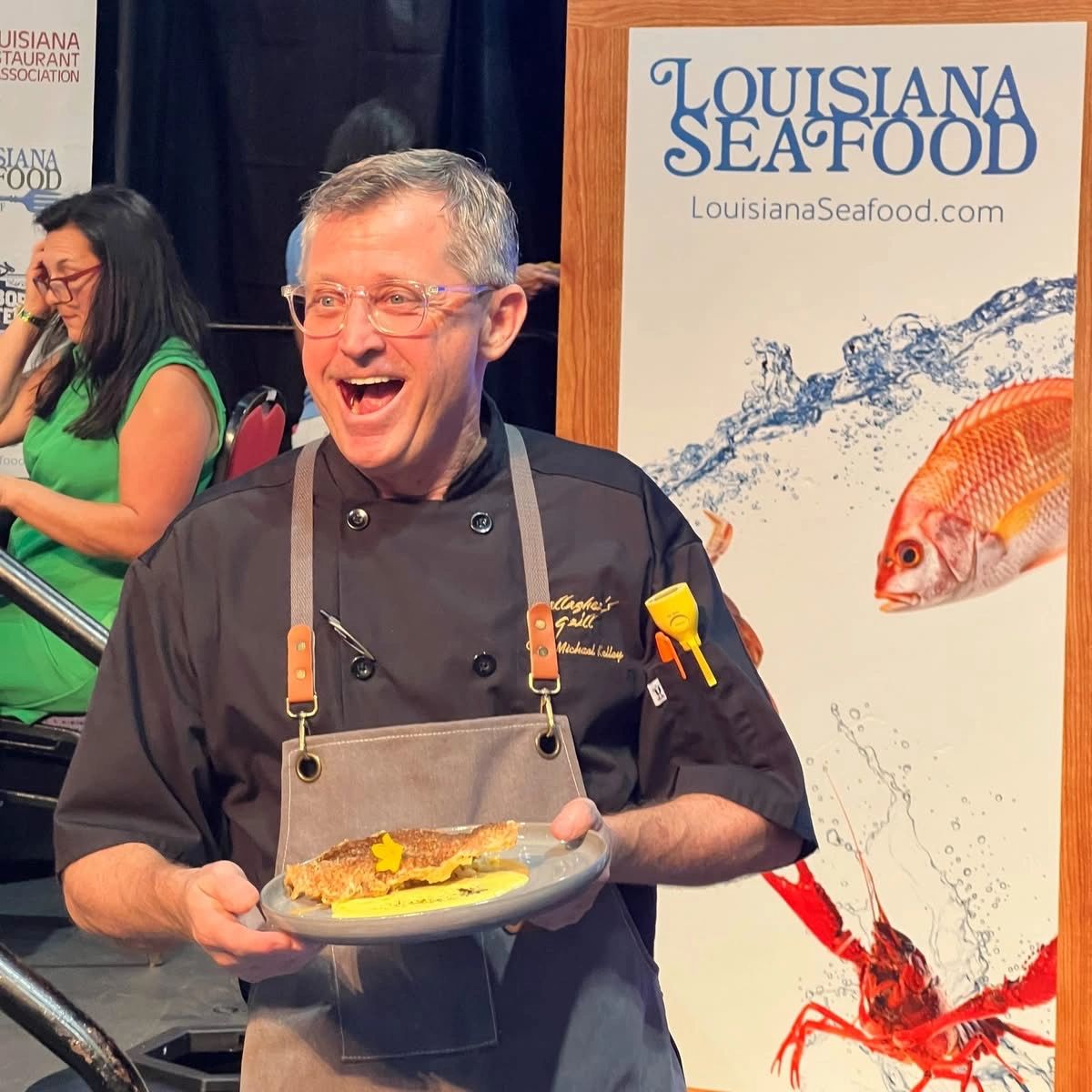 Chef proudly presents a seafood dish at a Louisiana Seafood event.