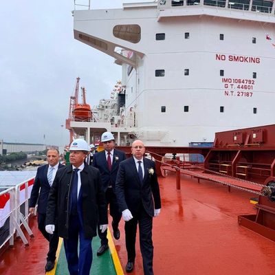 Group of men in formal attire walking on a ship deck.
