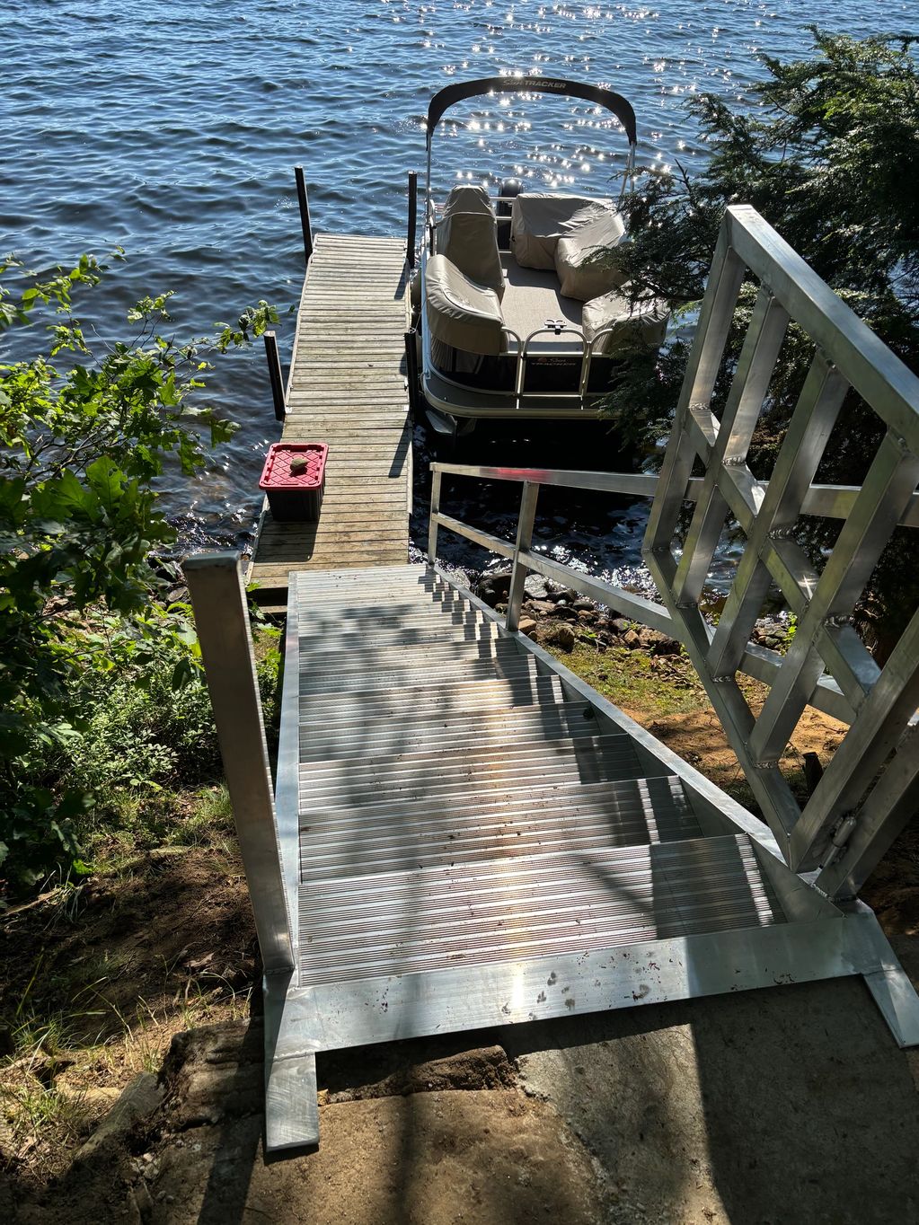 Lakefront aluminum staircase with swing gate and latch leading to dock.