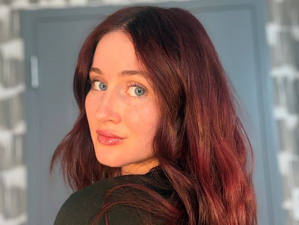 Woman with red hair looking over her shoulder.